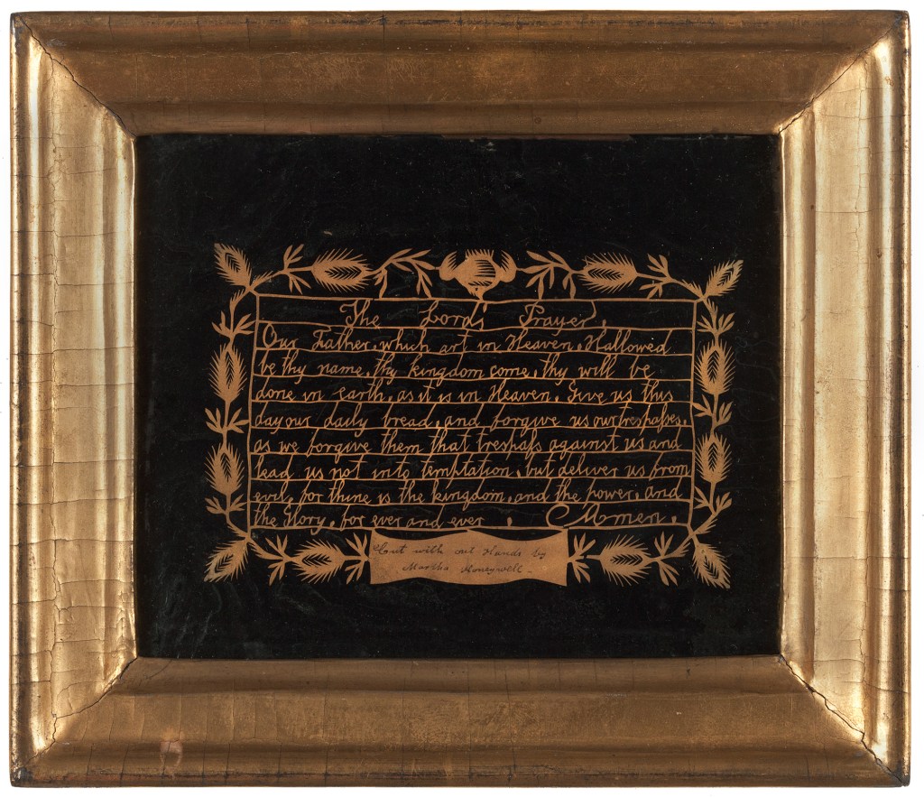 The Lord's Prayer, cut in beige paper with cut floral border, mounted on black paper with a gold frame.
