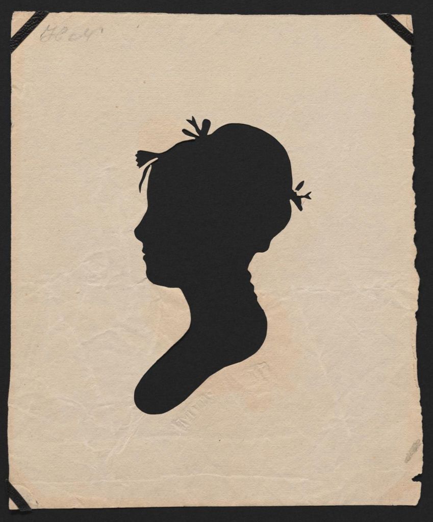 Silhouette portrait of of young woman with bows in hair.